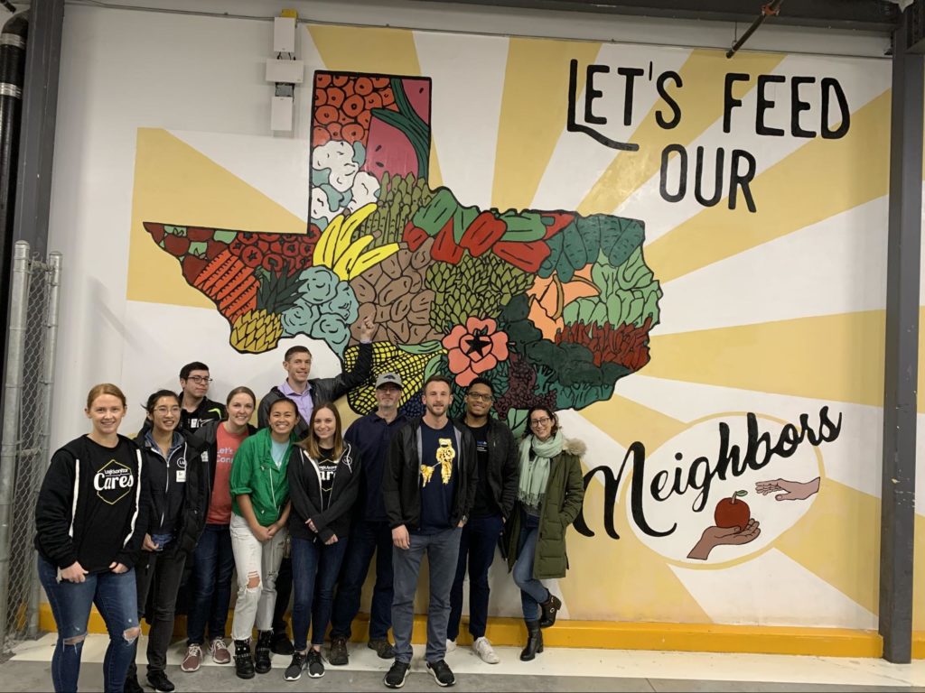 LogicMonitor employees pose outside the Central Texas Food Bank before volunteering to help prepare meals for those in need. 