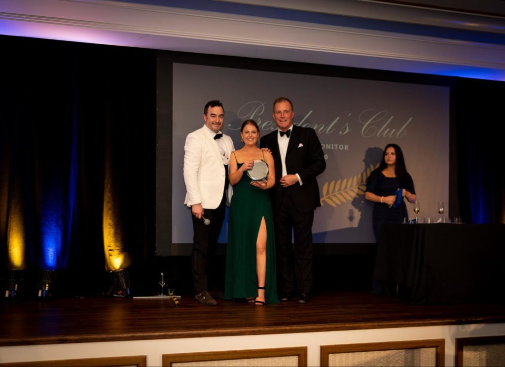 Talia McCurtain, center, accepting her award as the LogicMonitor Employee of the Year. CRO Mark Banfield, left, and CEO Kevin McGibben, right.